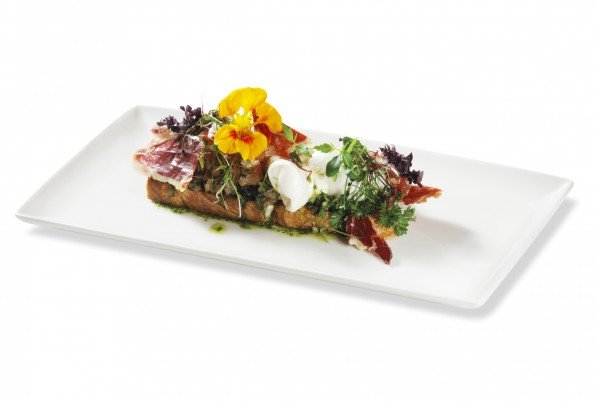 Cremosa burrata de la Pulla, làmines de pernil ibèric, pa de campanya torrat, entapissat amb cassé de tomàquet branca, tocs de alfàbrega fresca i el seu rajolí de verge extra.